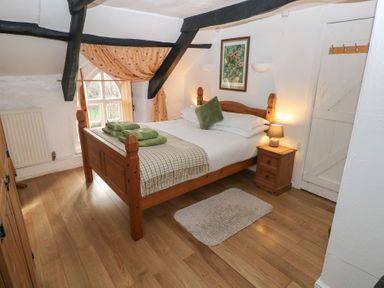 A bedroom with a bed and nightstand at Maesgwyn in Bridell near Cardigan