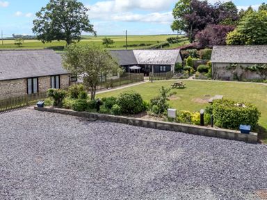 An outdoor area with buildings and garden features at New Barn in Winterborne Stickland