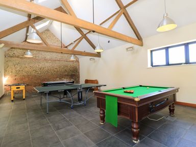 A game room with a pool table ping pong table and foosball table at The Old Cart Shed in Winterborne Stickland