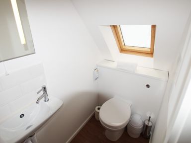 A small bathroom with a toilet and a sink under a skylight window at Beautiful Cotswold View in Bourton-On-The-Water
