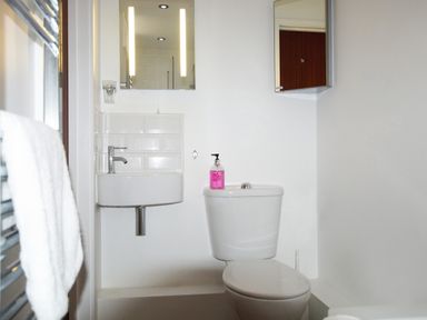 A bathroom with a toilet a sink a mirror and a towel on a radiator at Beautiful Cotswold View in Bourton-On-The-Water