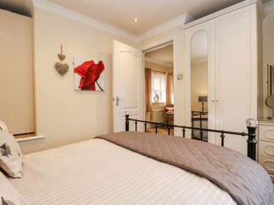 A bedroom with a bed a wardrobe with mirrored doors and a doorway leading to another room at Church View Ambleside