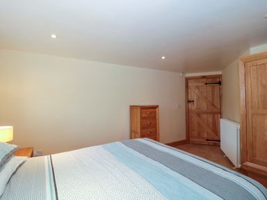 A bedroom with a bed and dresser at Longside in Gilwern