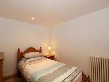 A bedroom with a bed and lamp at Longside in Gilwern