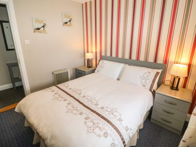 A bedroom with a double bed between two bedside tables with lamps at Island View in Ardmore County Waterford