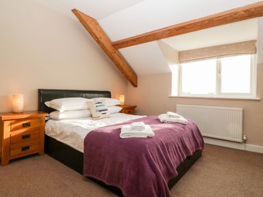 A bedroom with a double bed and wooden bedside tables at Ty Top in Llanfaethlu