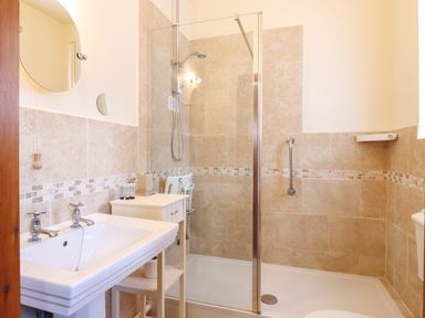 A bathroom with a walk-in shower sink cabinet and mirror at Barn Owl Cottage in Little Glemham near Wickham Market