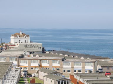 A coastal area with rows of houses and The Pier House Seafront Bar and Bistro near the sea at 37 Ocean Park in Westward Ho