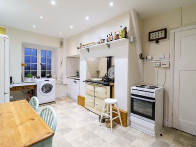 A kitchen with appliances and a table at Murmur Y Don in Harlech