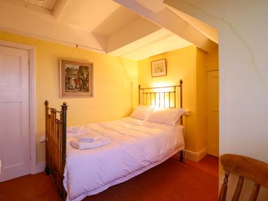 A bedroom with a bed and painting at Murmur Y Don in Harlech