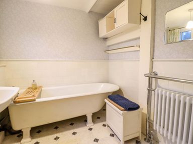 A bathroom with a bathtub and towel at Murmur Y Don in Harlech