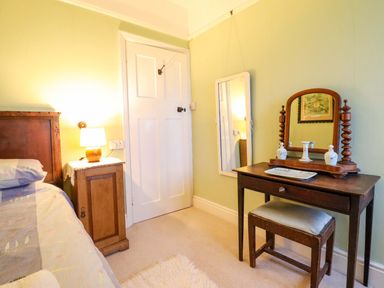 A bedroom with a bed and vanity table at Murmur Y Don, Harlech