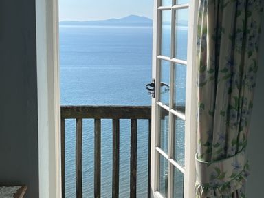 A balcony view overlooking water and mountains at Murmur Y Don in Harlech