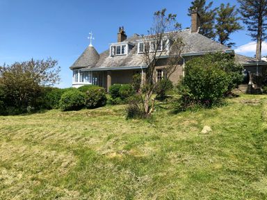 A house with trees and bushes in the garden at Murmur Y Don in Harlech