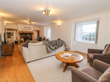 A living room with sofas a coffee table and a fireplace at East Farm House Humshaugh near Hexham