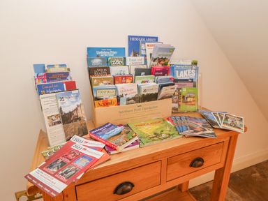A wooden table with brochures and pamphlets about local attractions and events at East Farm House in Humshaugh near Hexham