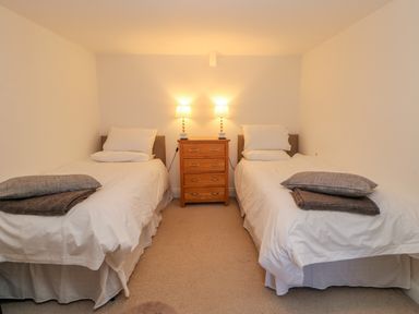 A bedroom with two single beds and a wooden chest of drawers with lamps at East Farm House Humshaugh near Hexham
