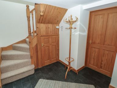 A hallway with stairs and a coat rack at Bwthyn-y-Rhiw Penybank near Llandeilo