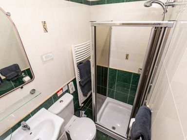 A bathroom with a shower cubicle a toilet a sink a mirror and towels at Browside Little Arrow near Coniston