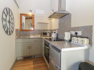 A kitchen with appliances and storage at Tawny Owl Barn Shipdham near Dereham