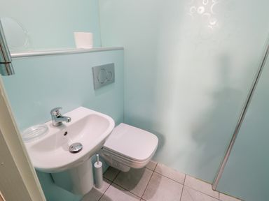 A small bathroom with a white sink and wall-mounted toilet at Nutshell in Whitby
