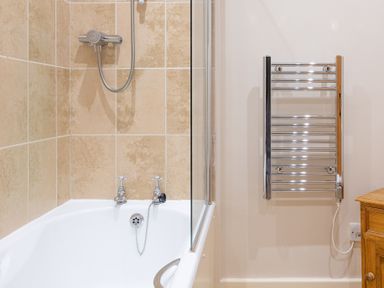 A bathroom with a bathtub shower and a chrome towel radiator at Crabtree in Hawkshead