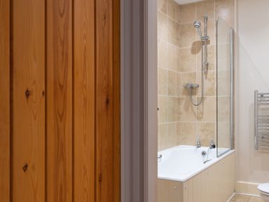 A bathroom with a bathtub shower combination and a towel rack at Crabtree in Hawkshead