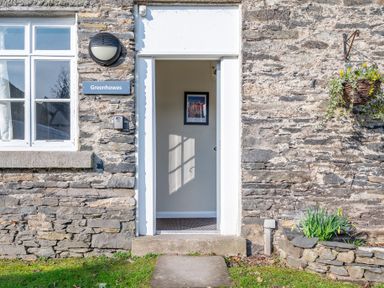 Stone exterior wall with an open doorway and window at Greenhowes Graythwaite near Hawkshead