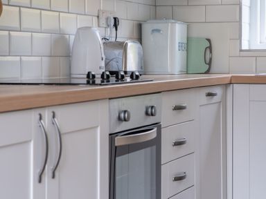 A kitchen countertop with a kettle toaster bread bin and oven at Greenhowes in Graythwaite near Hawkshead