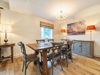A dining room with a wooden table and six chairs at Jubilee at the Graythwaite Estate Graythwaite near Hawkshead