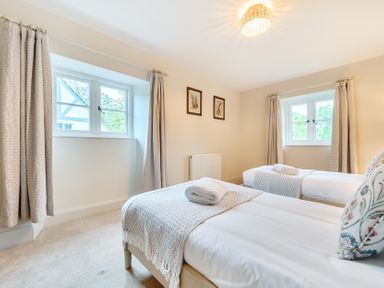 A bedroom with two beds and a window at Jubilee at the Graythwaite Estate in Graythwaite near Hawkshead
