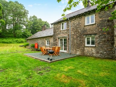 An outdoor dining setup with chairs and a grill at Jubilee at the Graythwaite Estate near Hawkshead