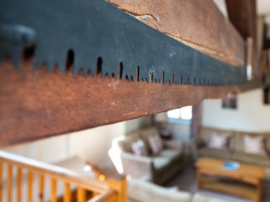 A close up of a wooden saw mounted on a wooden beam in a living room at Lords Leap in Graythwaite near Hawkshead