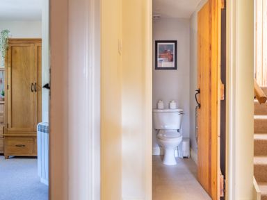 A hallway view showing a bathroom with a toilet and a framed picture above it at Lords Leap Graythwaite near Hawkshead
