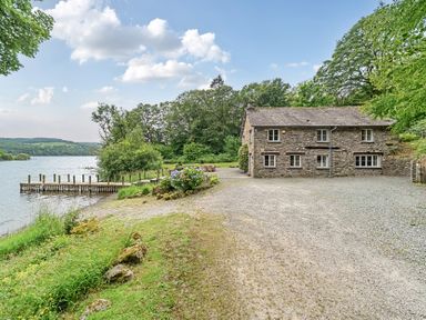 A house by a lake with a dock at Hammerhole at the Graythwaite Estate near Hawkshead