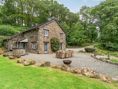 An outdoor area with a house, table and chairs at Hammerhole at the Graythwaite Estate near Hawkshead