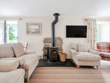 A living room with a fireplace and seating area at Hammerhole at the Graythwaite Estate near Hawkshead