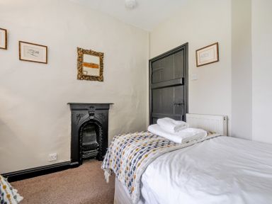 A bedroom with a bed and fireplace at Hullet Hall at the Graythwaite Estate near Hawkshead