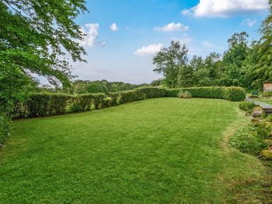 A garden with grass and bushes at Hullet Hall at the Graythwaite Estate near Hawkshead