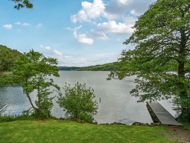 A view of a lake with trees and a dock at Hullet Hall at the Graythwaite Estate near Hawkshead