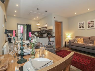 A kitchen and dining area with a table and sofa at The Stable in Deepdean near Ross-on-Wye