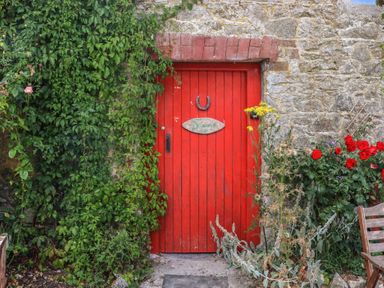 A red door with a sign and flowers at Mrs Delaney's Loft Ardfinnan near Clonmel County Tipperary