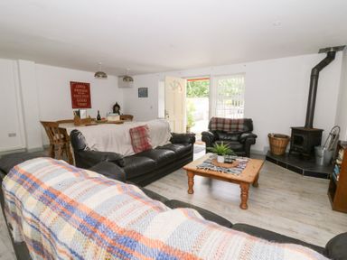 A living room with a sofa and coffee table at Cariad Cottage in Cross Inn