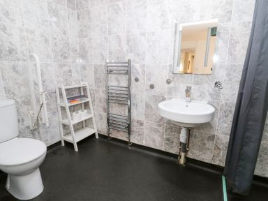 A bathroom with a toilet, sink, and towel rail at Cariad Cottage in Cross Inn