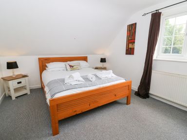 A bedroom with a bed and bedside table at Cariad Cottage in Cross Inn