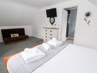 A bedroom with a bed and television at Cariad Cottage in Cross Inn