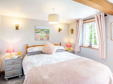 A bedroom with a bed and pink lamps on bedside tables at Bwythyn Y Wennol in Nantmor near Beddgelert