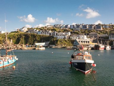 A harbor with boats on the water and houses on a hill at Nectan in Mevagissey