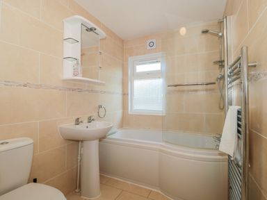 A bathroom with a toilet sink bathtub shower and heated towel rail at Bramley Lodge in Hewish near Weston-super-Mare