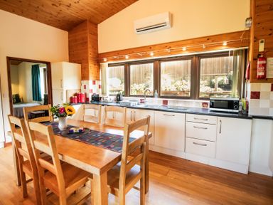 A kitchen with dining table and chairs at Sycamore Lodge Nantmel near Rhayader